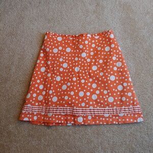 Larry Levine stretch orange and white dotted skort